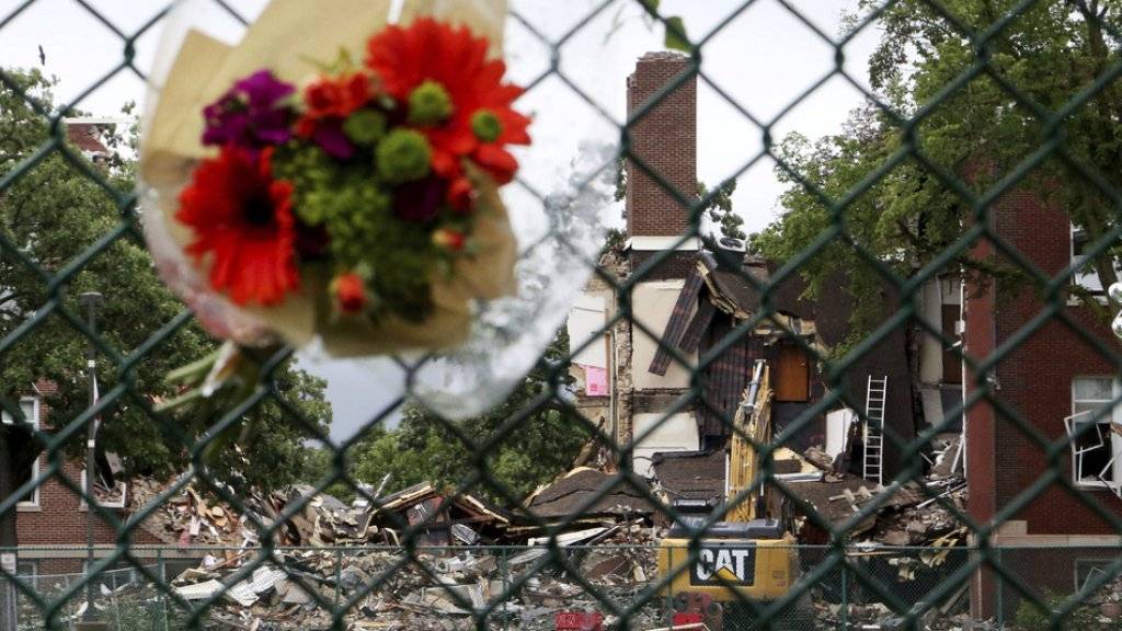 Blumen stecken in einem Zaun bei der Privatschule in Minnehaha, wo sich eine tödliche Gasexplosion ereignete.