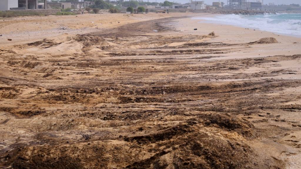 Dunkle Ölrückstände bedecken Teile der Küste am Shib-Deraz-Strand auf der Insel Gheschm. Foto: Amirhosein Khorgooi/ISNA/AP/dpa