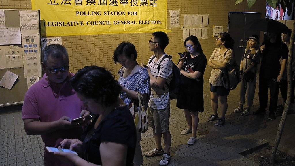 Hongkonger stehen vor einem Wahllokal an, um ihre Stimme abzugeben.