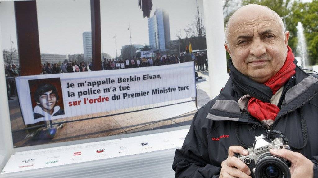 Demir Sönmez posiert vor der Fotografie, welche die türkischen Behörden erzürnt hat. Der Genfer Fotograf mit kurdischen und armenischen Wurzeln stellt auf auf der Place des Nations in Genf bis am Sonntag 58 Fotografien von auf dem Platz durchgeführten Demonstrationen aus.