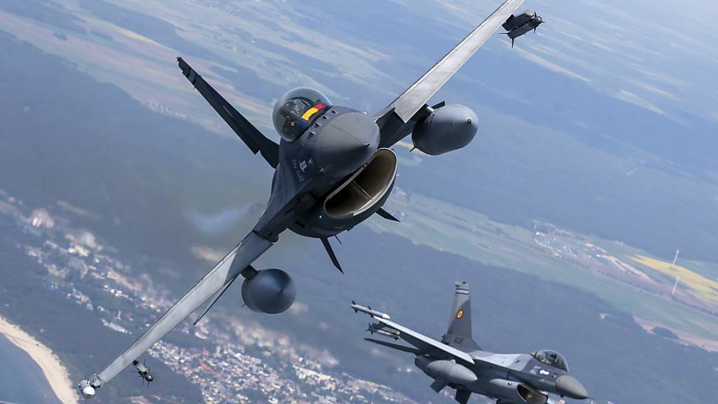 ARCHIV - Ein Kampfjet von Typ F-16 der rumänischen Luftwaffe (l) und ein Kampfjet des selben Typs der portugiesischen Luftwaffe fliegen über der Ostsee im litauischen Luftraum während der Baltic Air Policing Mission der NATO. Foto: Mindaugas Kulbis/AP/dpa