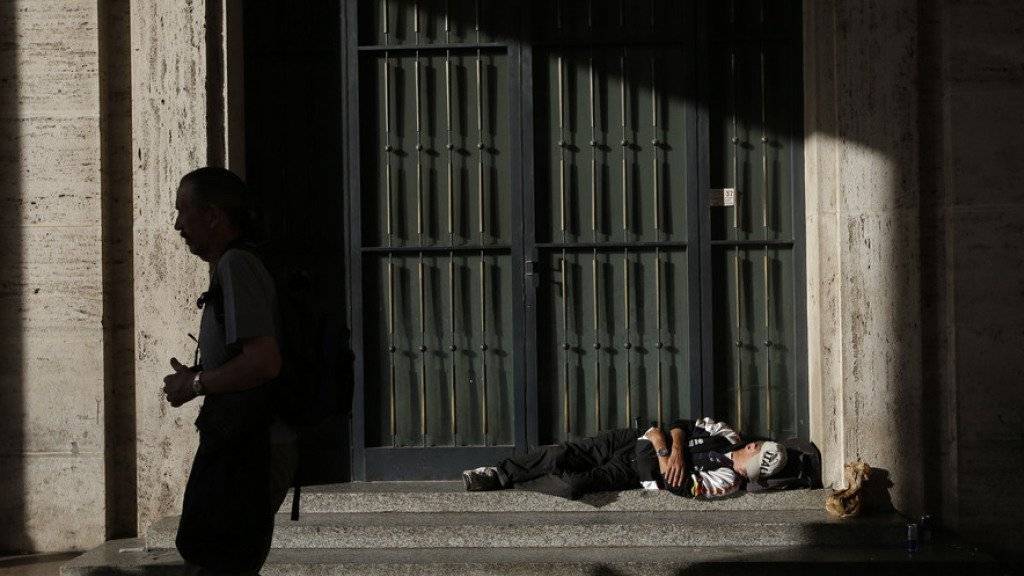 Ein Obdachloser schläft vor einem Gebäude in Rom (Symbolbild/Archiv)