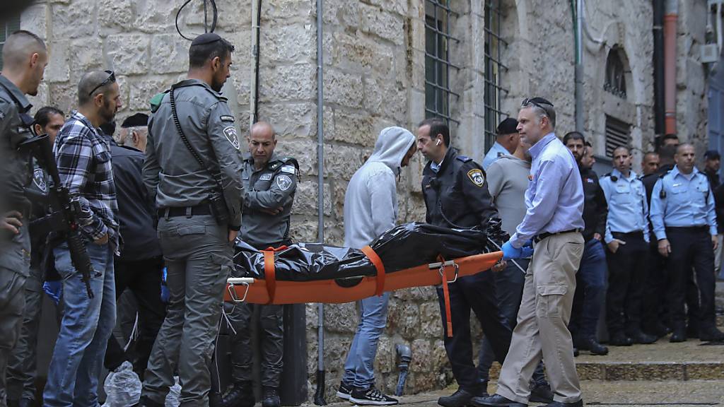Die Leiche eines palästinensischen Mannes, der von der israelischen Polizei erschossen wurde, wird weggetragen. Der Mann hatte zuvor nach Krankenhausangaben bei einem Schusswechsel in der Jerusalemer Altstadt einen Israeli getötet und drei weitere Menschen verletzt. Foto: Mahmoud Illean/AP/dpa