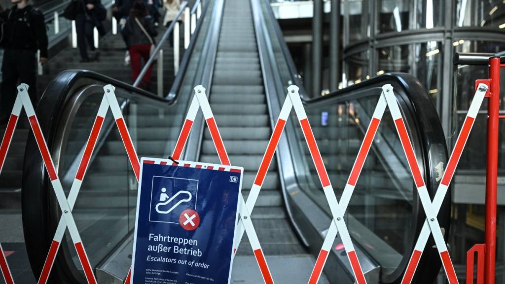 Fahrgäste tragen ihre Koffer am Berliner Hauptbahnhof über die Treppe. Foto: Britta Pedersen/dpa
