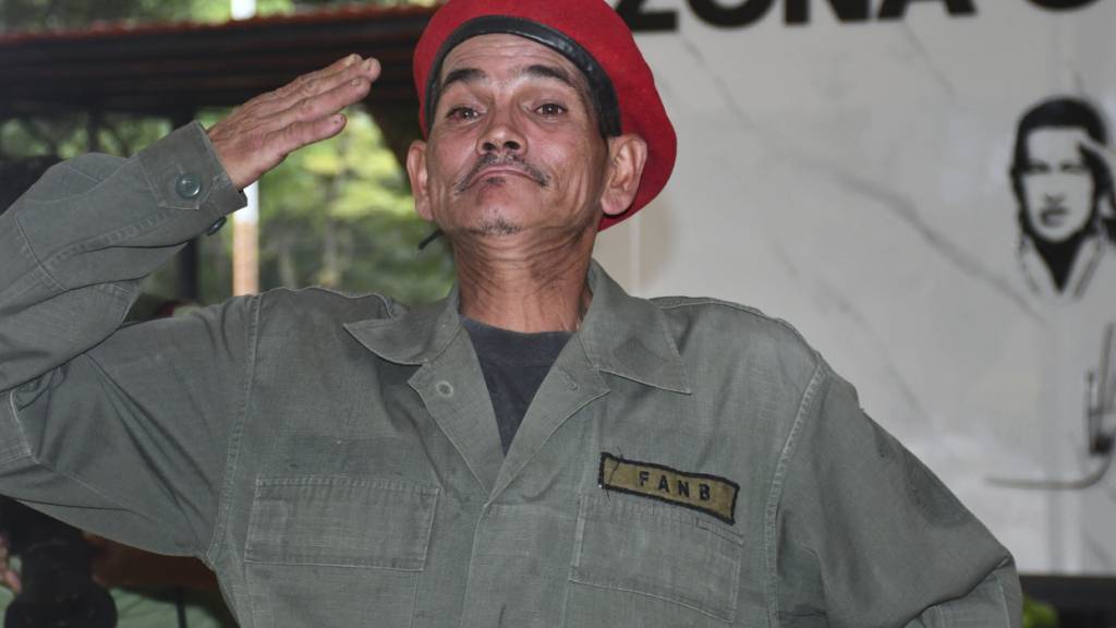 Ein Mann salutiert. Foto: Jacinto Oliveros/AP/dpa