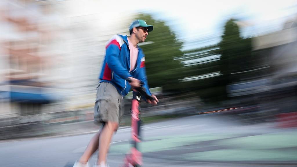 Ein Mann ist auf einem E-Scooter unterwegs.