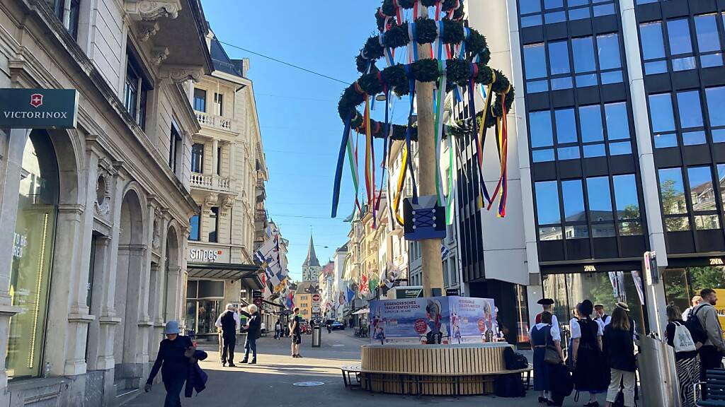 Ein traditioneller Maibaum steht an der Zürcher Bahnhofstrasse - er kündigt das Eidgenössische Trachtenfest von Ende Juni an.