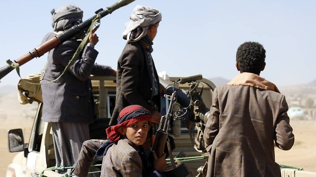 Huthi-Rebellen sitzen auf der Ladefläche eines Fahrzeugs in Sanaa, Jemen. Foto: Uncredited/AP/dpa