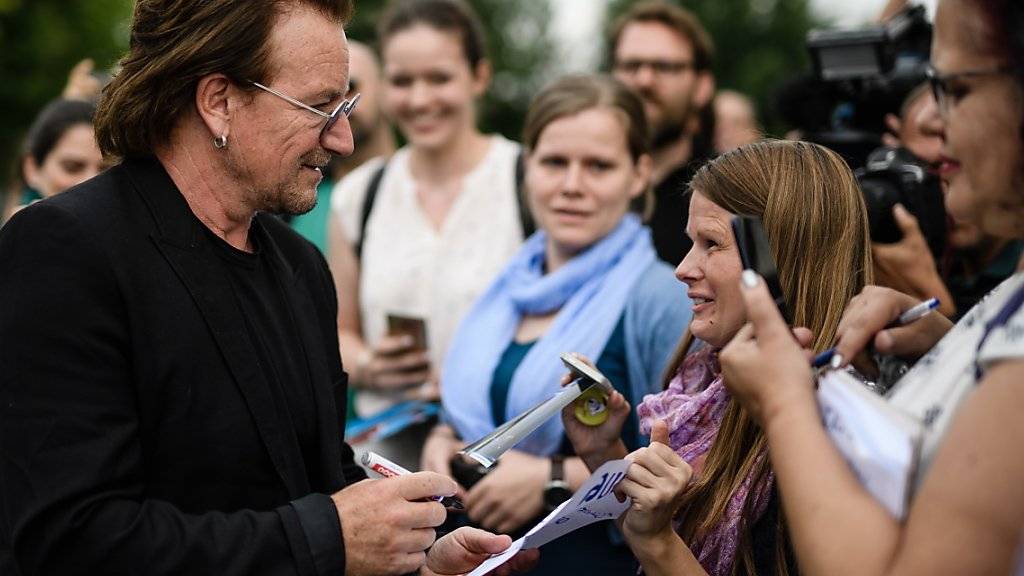 U2-Sänger Bono spricht mit Fans, nachdem er vergangene Woche mit der deutschen Kanzlerin Angela Merkel über Entwicklungshilfe in Afrika gesprochen hat. Bei einem Konzert in Berlin hat am Samstag seine Stimme versagt und die Veranstaltung musste abgebrochen werden.
