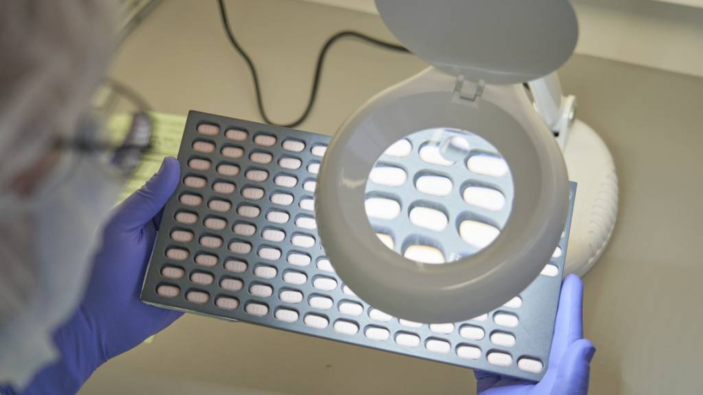 Ein Pfizer-Mitarbeiter in Freiburg untersucht Paxlovid-Tabletten.  (Pfizer via AP)