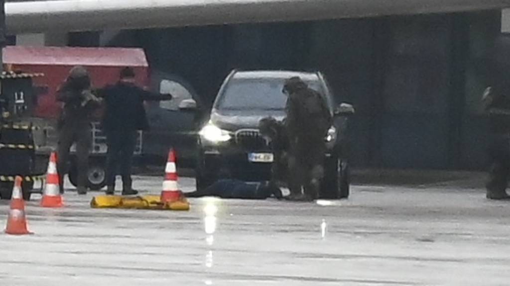 Ein Mann liegt auf dem Hamburger Flughafen auf dem Boden, umringt von Polizeikräften. Foto: Jonas Walzberg/dpa