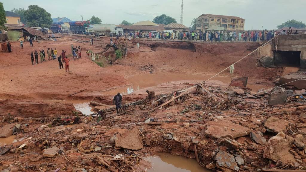 Menschen suchen in einem überfluteten Gebiet nach einem Regenguss in Mokwa, Nigeria. Foto: Chenemi Bamaiyi/AP/dpa