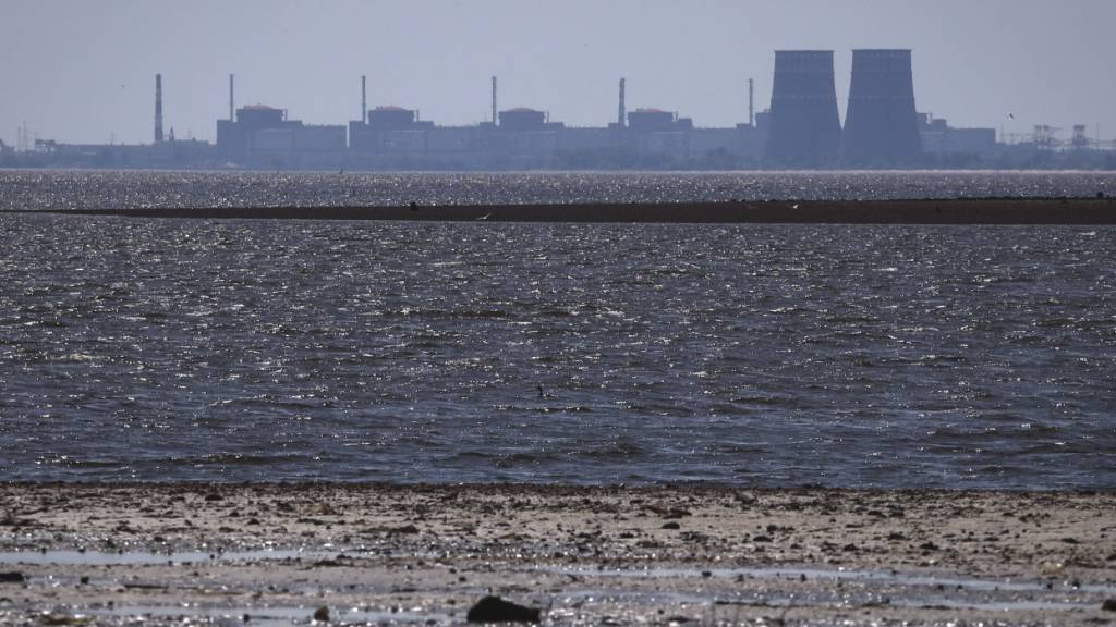 ARCHIV - Das von russischen Truppen besetzte Kernkraftwerk Saporischschja ist im Hintergrund des flachen Kachowka-Stausees nach der Zerstörung des Staudamms zu sehen. Foto: Kateryna Klochko/AP/dpa