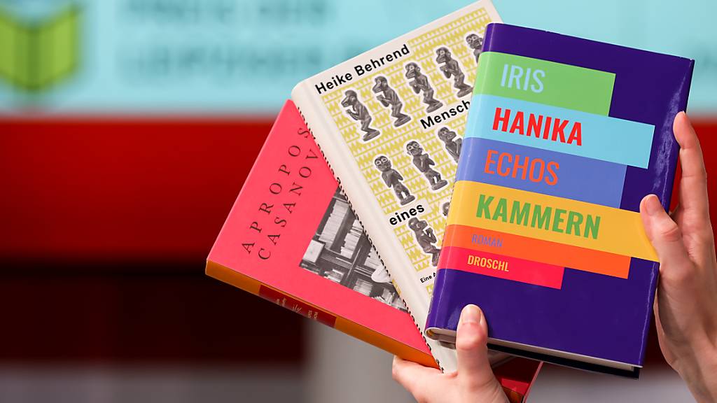 Eine Frau hält die drei siegreichen Bücher beim letzten Preis der Leipziger Buchmesse.