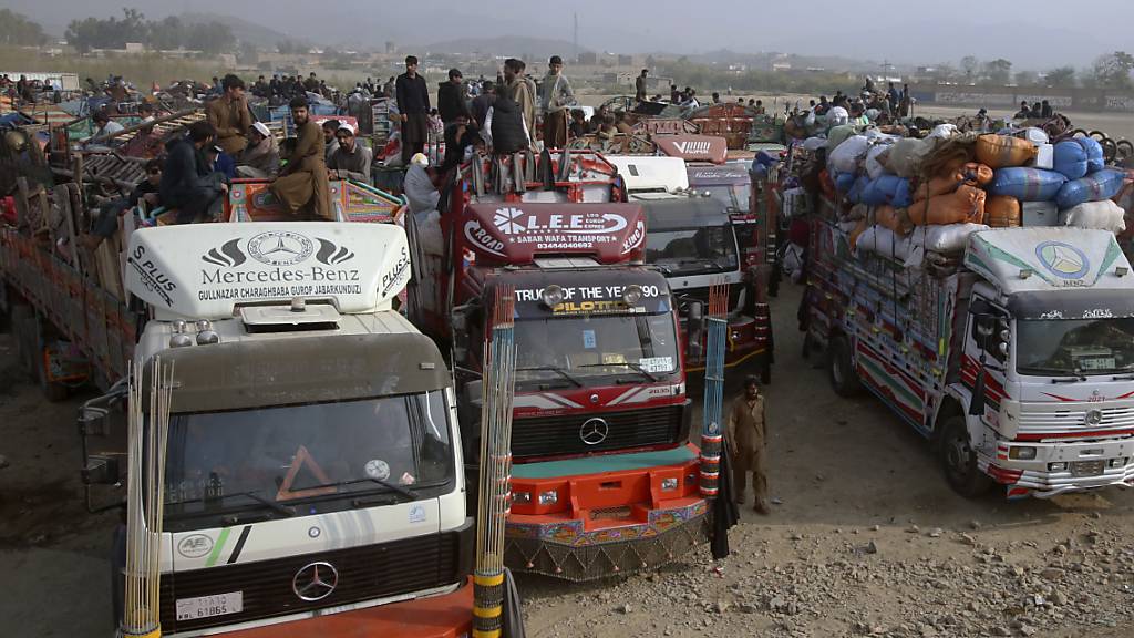 dpatopbilder - Afghanische Familien warten auf die Abfertigung an einem Grenzübergang in Torkham. Foto: Muhammad Sajjad/AP/dpa