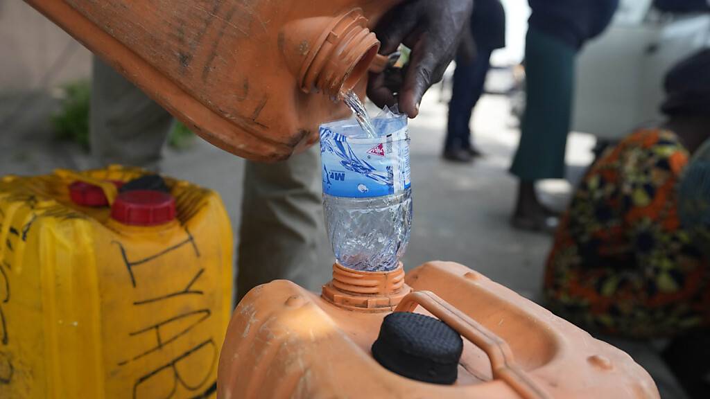 ARCHIV - Ein Mann verkauft Kraftstoff in der Nähe einer Tankstelle in Nigeria (Archivbild). Foto: Sunday Alamba/AP/dpa