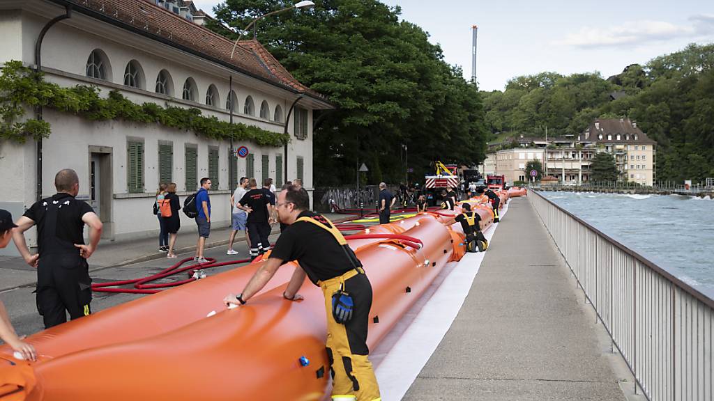 Die Feuerwehr fuellt Wassersperren wegen dem drohenden Hochwasser der Aare im Mattequartier. (KEYSTONE/Peter Klaunzer)