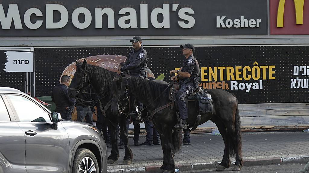 Berittene Polizisten inspizieren den Ort eines Anschlags in Beerscheba im Süden Israels. Foto: Tsafrir Abayov/AP/dpa