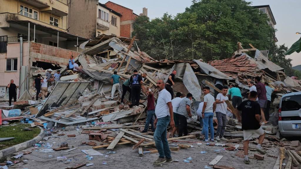 dpatopbilder - Menschen beseitigen die Trümmer eines eingestürzten Gebäudes nach einem Erdbeben in Sindirgi in der Westtürkei. Foto: Bahadir Demirceviren/IHA/AP/dpa