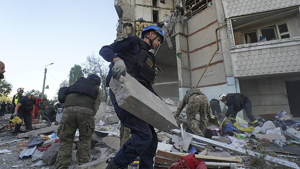 Rettungskräfte und Soldaten versuchen, Schutt und Trümmer nach einem russischen Angriff auf ein Wohnhaus zu bewegen. Foto: Andrii Marienko/AP/dpa