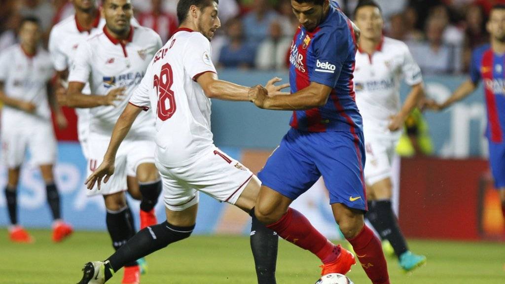 Luis Suarez (rechts) stellt Sevillas Sergio Escudero nach seiner Einwechslung vor Probleme