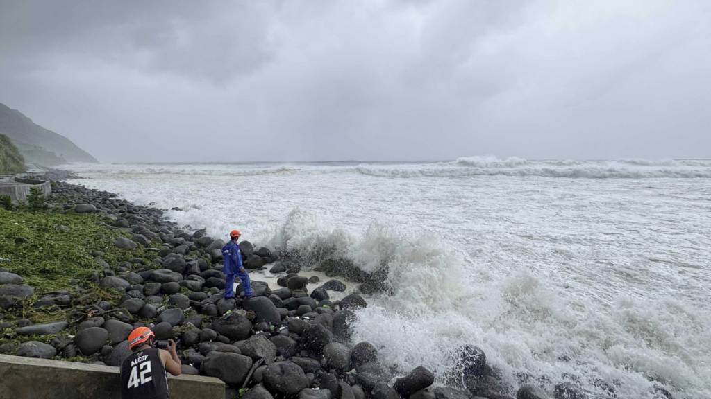dpatopbilder - Menschen beobachten, wie starke Wellen auf Basco in der Provinz Batanes im Norden der Philippinen einschlagen, als der Taifun Ragasa das Gebiet am Montag, den 22. September 2025, trifft. Foto: Justine Mark Pillie Fajardo/AP/dpa