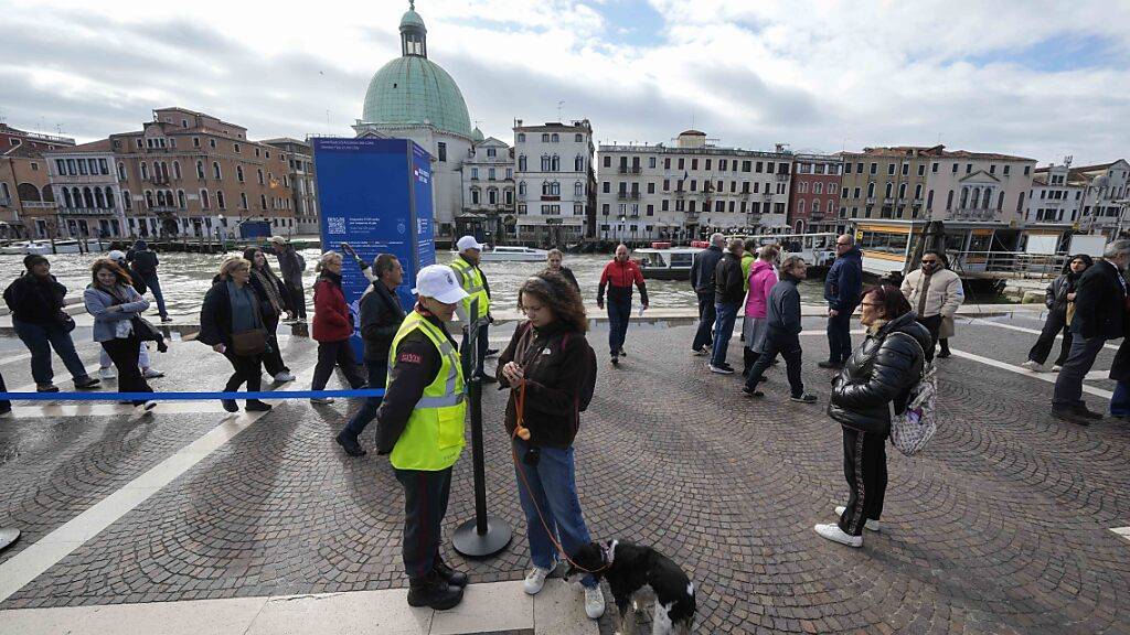 Kontrolleure überprüfen den QR-Code der Touristen vor dem Hauptbahnhof. Foto: Luca Bruno/AP/dpa