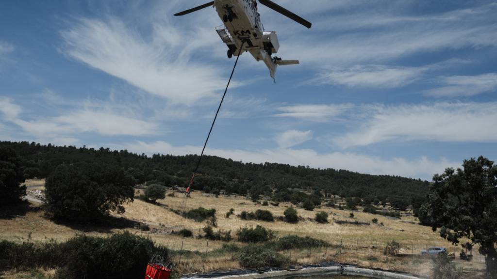 dpatopbilder - Ein Hubschrauber bei Löscharbeiten in La Mierla, Guadalajara, Kastilien-La Mancha (Spanien). Das Feuer brennt weiterhin an mehreren Fronten und breitet sich in Richtung der Ortschaft Semillas aus. Foto: Mateo Lanzuela/EUROPA PRESS/dpa