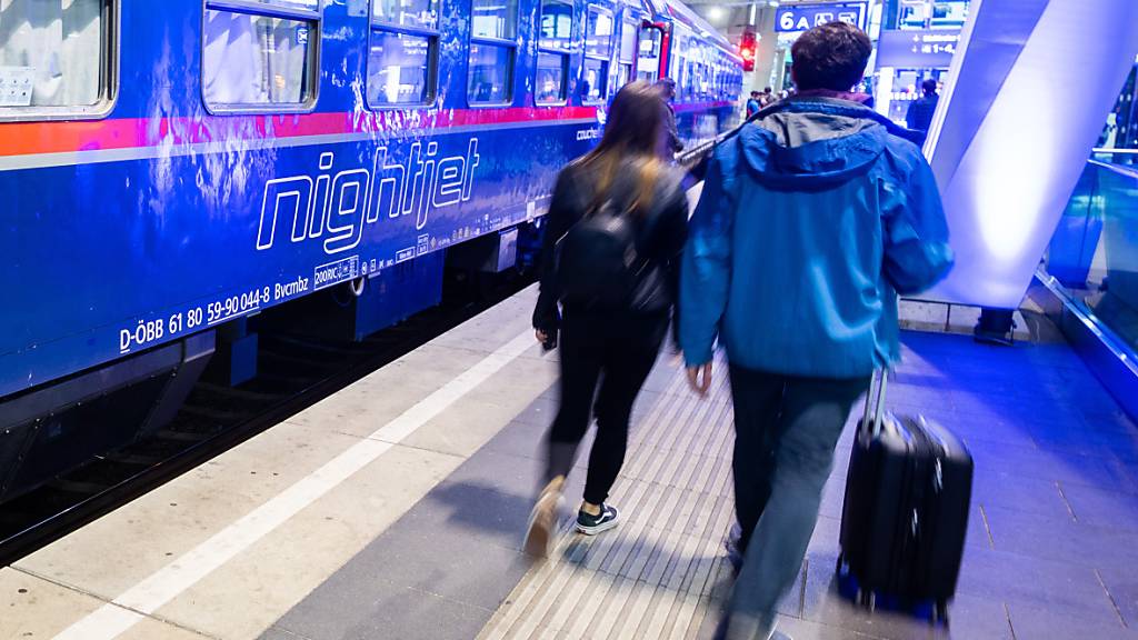 ARCHIV - Passagiere gehen neben einem Zug der ÖBB auf einem Gleis im Wiener Hauptbahnhof. Foto: Georg Hochmuth/APA/dpa