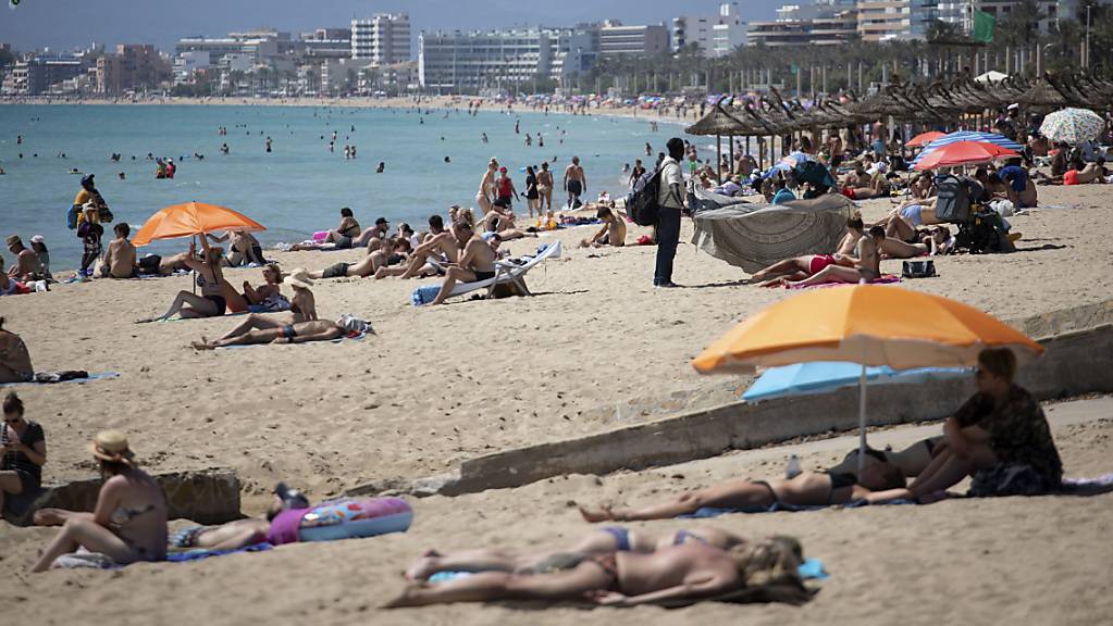 Touristen sonnen sich auf Mallorca: Die Insel will trotz steigender Coronazahlen keine neuen Einschränkungen verhängen.