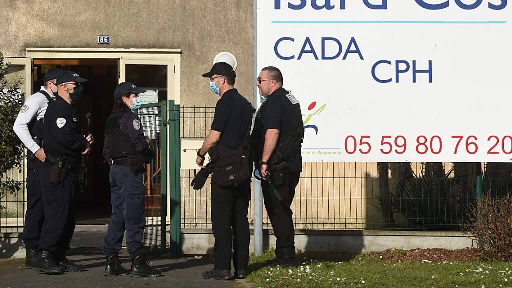 Polizeibeamte stehen vor dem Eingang des Isard Cos Aufnahmezentrums für Geflüchtete (CADA), in dem ein Mann mit einem Messer getötet worden sein soll.