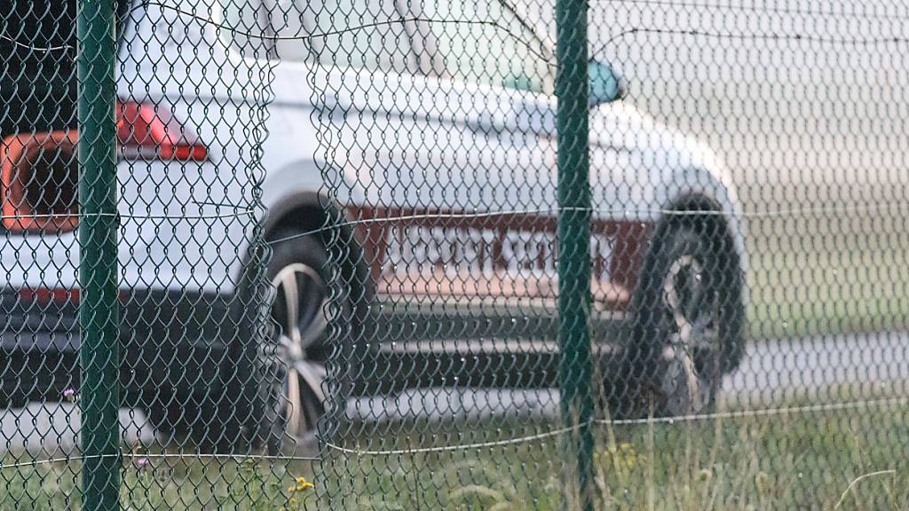 Ein Auto der Flughafensicherheit des Flughafen Berlin-Brandenburg BER steht hinter dem Zaun des Flughafens. Die Polizei geht davon aus, dass Aktivisten der Klima-Initiative Letzte Generation durch das sichtbare Loch im Zaun auf das Gelände des Flughafens gelangt sind. Foto: Julius Schreiner/dpa
