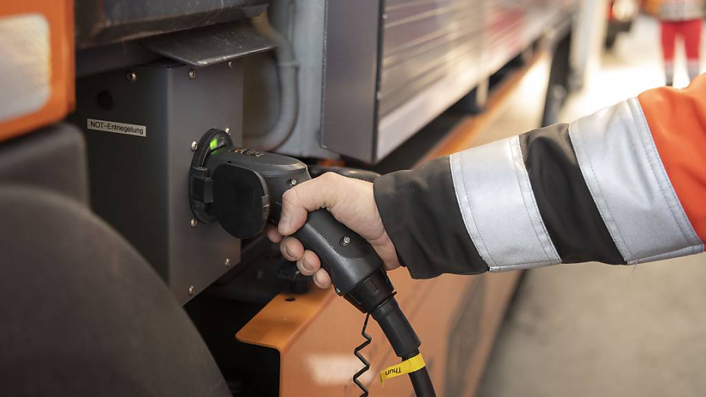 Ein Angestellter der Stadt Thun lädt einen elektrisch betriebenen Kehrichtlastwagen auf. (Archivbild)
