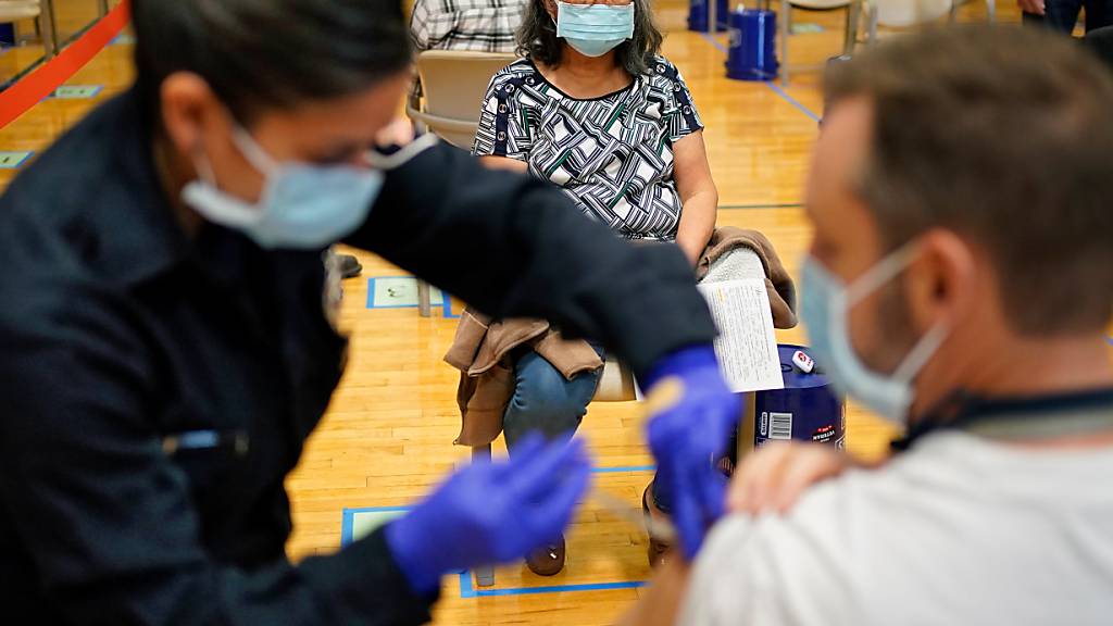ARCHIV - Menschen erhalten den COVID-19-Impfstoff an einer Impfstelle in Las Vegas. Foto: John Locher/AP/dpa