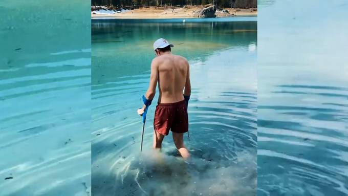 Andri Ragettli badet mit Krücken im Caumasee