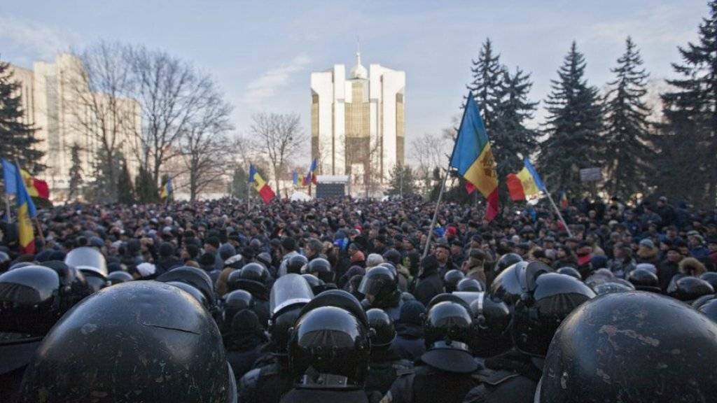 Polizisten treten vor dem Parlamentsgebäude in Chisinau den Demonstranten entgegen