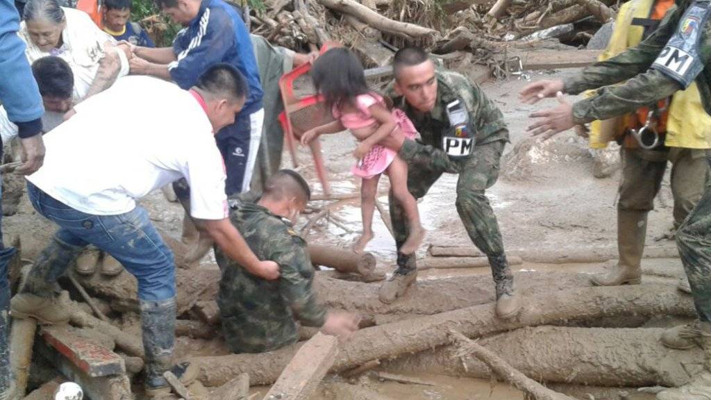 Rettungskräfte bergen in der betroffenen Stadt Mocoa Menschen, die vom Erdrutsch erfasst wurden.