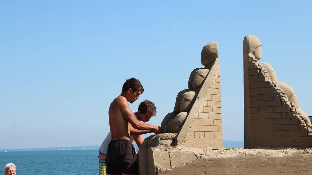 Die beiden Russen Aleksandr und Vladimir arbeiten konzentriert an ihrer Sandskulptur. (Bild: FM1Today/Krisztina Scherrer)