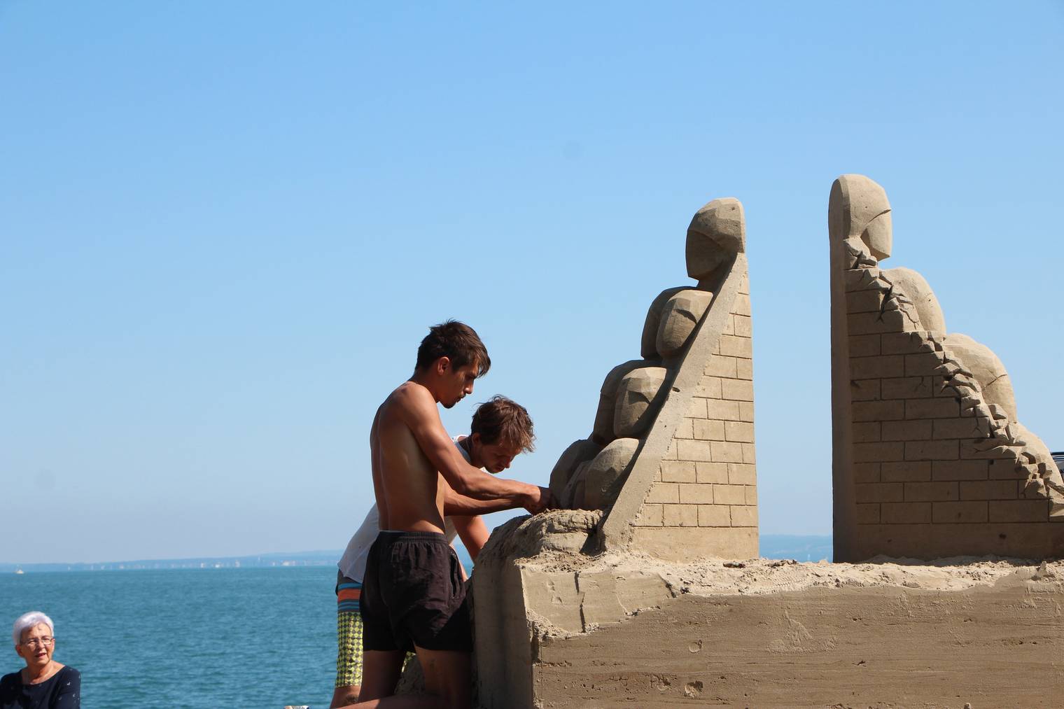 Die beiden Russen Aleksandr und Vladimir arbeiten konzentriert an ihrer Sandskulptur. (Bild: FM1Today/Krisztina Scherrer)