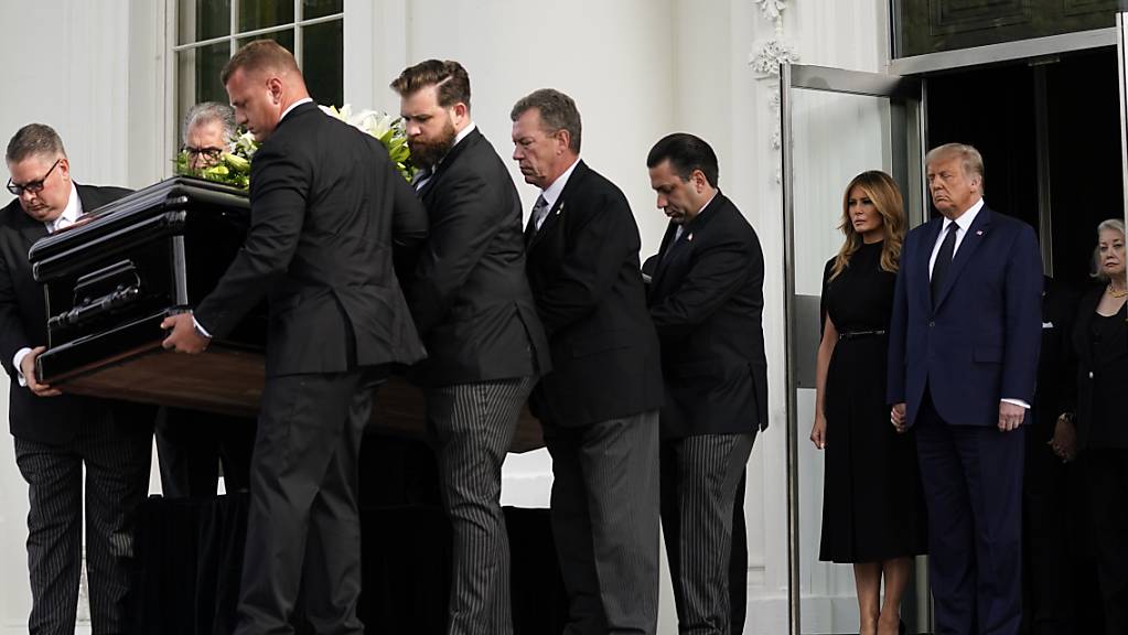 US-Präsident Donald Trump und First Lady Melania Trump stehen nebeneinander, während der Sarg von Robert Trump nach einer Gedenkfeier im Weißen Haus in einen Leichenwagen geladen wird.