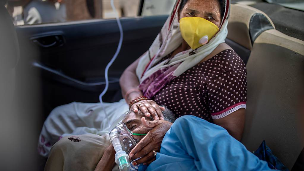 Ein Patient atmet mit Hilfe von Sauerstoff in einem Auto in Neu-Delhi. In Indien hat es den fünften Tag in Folge einen weltweiten Rekord bei den Corona-Neuinfektionen gegeben. Foto: Altaf Qadri/AP/dpa