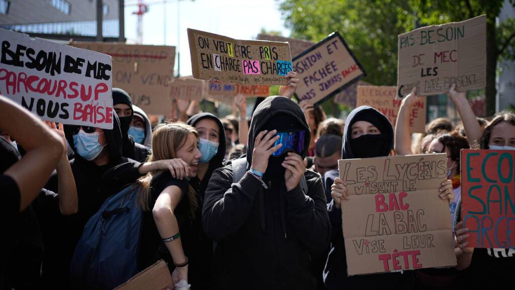 ARCHIV - Ein Schüler hält ein Schild mit der Aufschrift «Wir wollen unterstützt und nicht überlastet werden» während einer Demonstration gegen unterfinanzierte Schulen vor einer Blockade vor einem Gymnasium. Seit Tagen protestieren Schülerinnen und Schüler an den Oberschulen. Foto: Laurent Cipriani/AP/dpa