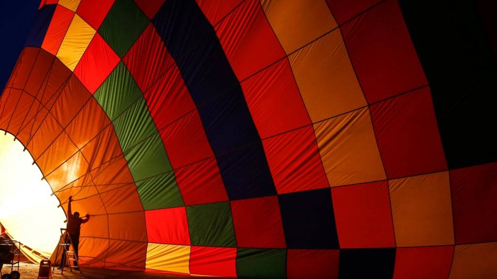 ARCHIV - Ein Heißluftballon wird mit heißer Luft gefüllt, bevor er bei Sonnenaufgang in den Himmel steigt. Foto: Emrah Gurel/AP/dpa