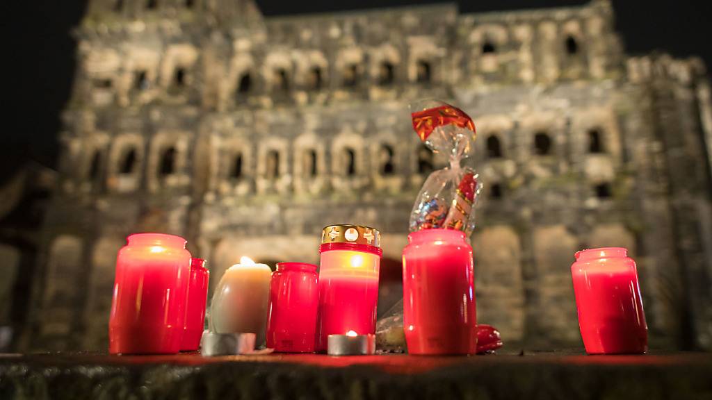 Vor der Porta Nigra brennen Kerzen. Am Nachmittag war ein Mann mit einem Auto durch die Fußgängerzone von Trier gefahren und hat dabei Menschen verletzt und getötet. Foto: Oliver Dietze/dpa