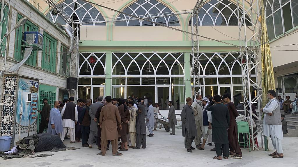 Menschen stehen in einer Moschee nach einer Explosion. Laut Mitteilung der staatlichen Nachrichtenagentur Bachtar m Freitag sind bei einer Serie von Selbstmordanschlägen auf eine schiitische Moschee in der südafghanischen Stadt Kandahar mindestens 32 Menschen getötet worden. Foto: Sidiqullah Khan/AP/dpa