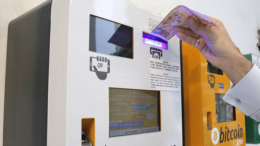 Die Kryptowährung Ether hat ein Kurshoch erreicht. Im Bild: Eine Person benutzt einen Ether-Geldautmoaten in Hongkong, der neben einem Bitcoin-Geldautomaten steht. (Symbolbild)