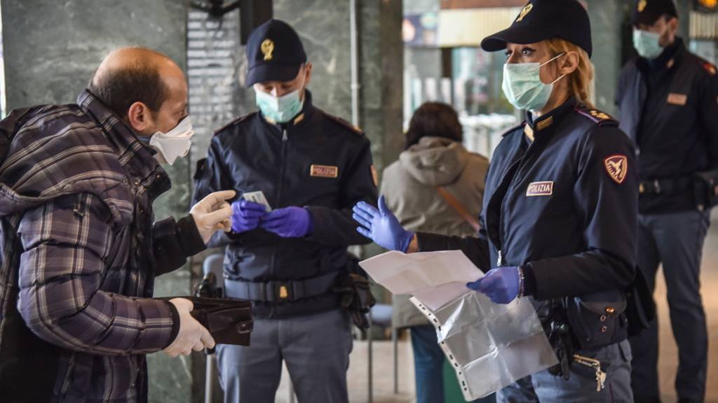 Italienische Polizisten checken Reisende beim Verlassen des Bahnhofs in Mailand. EPA Fotograf: MATTEO CORNER