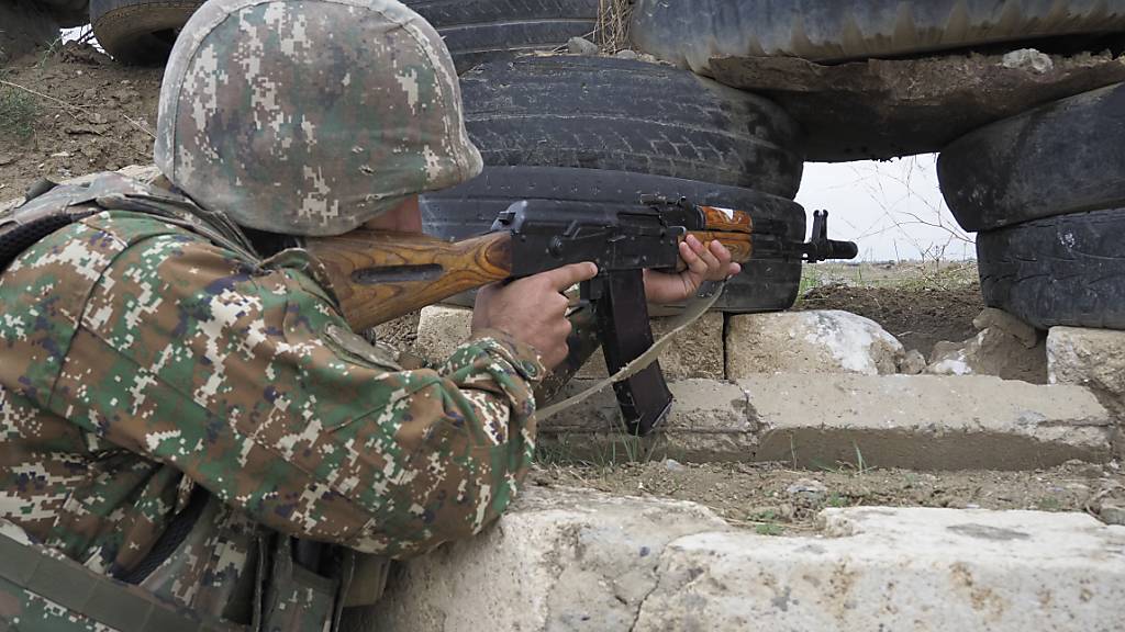Ein armenischer Soldat zielt in Richtung der aserbaidschanischen Stellungen. Foto: -/AP/dpa