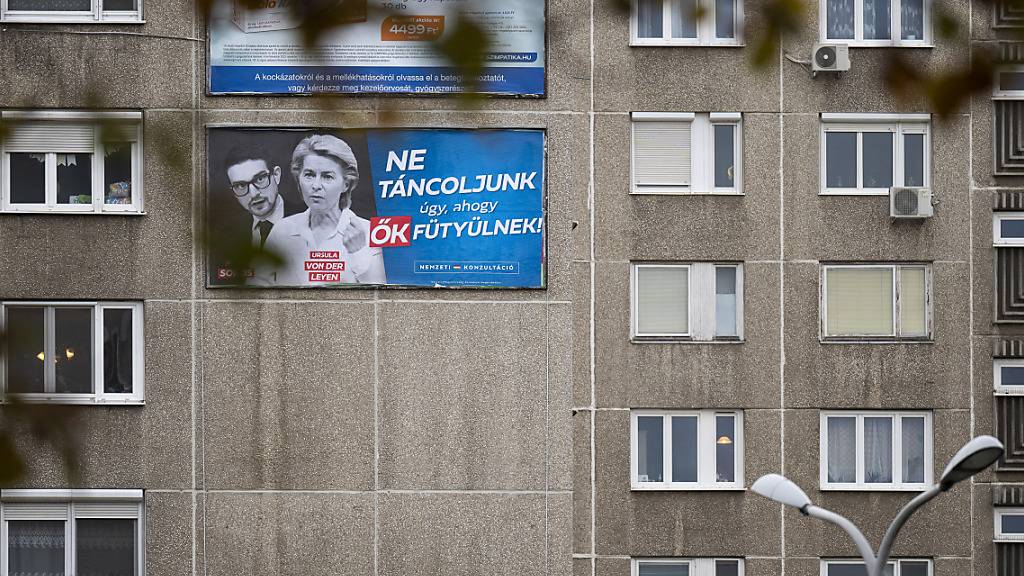 Ein Plakat von Ungarns rechtspopulistischer Regierung mit der Aufschrift «Lasst uns nicht nach ihrer Pfeife tanzen» ist mit Porträts von Alex Soros (l) und Ursula von der Leyen, Präsidentin der Europäischen Kommission, an der Fassade eines Wohnhauses zu sehen. Foto: Denes Erdos/AP
