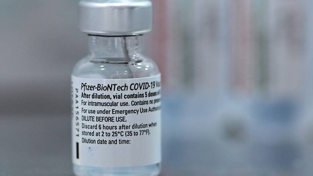 Im Impfzentrum Cottbus steht eine kleine Ampulle mit einer Kanüle für die Impfung gegen Covid-19 mit dem Impfstoff von Biontech/Pfizer. An diesem Tag hatten die beiden Impfzentren in Potsdam und Cottbus ihren Betrieb aufgenommen. Foto: Patrick Pleul/dpa-Zentralbild/dpa